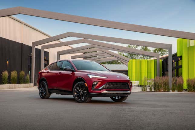 A red Buick Envista parked in front of some cool architectural structures.